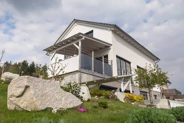Das individuelle Fertighaus in Steinen (Baden) liegt mitten im Grünen. Bodentiefe Fenster sorgen auch innen für viel Tageslicht und helle, freundliche Räume.