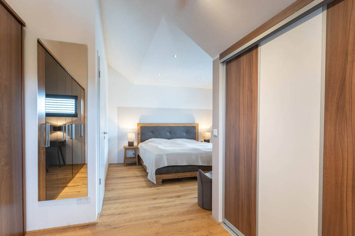 Das moderne und helle Elternschlafzimmer bietet eine Ruhezone im individuellen Fertighaus.