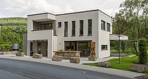 Musterhaus Satchmo mit vielen Fenstern, zwei Terrassen, Loggia und Balkon bei Nacht