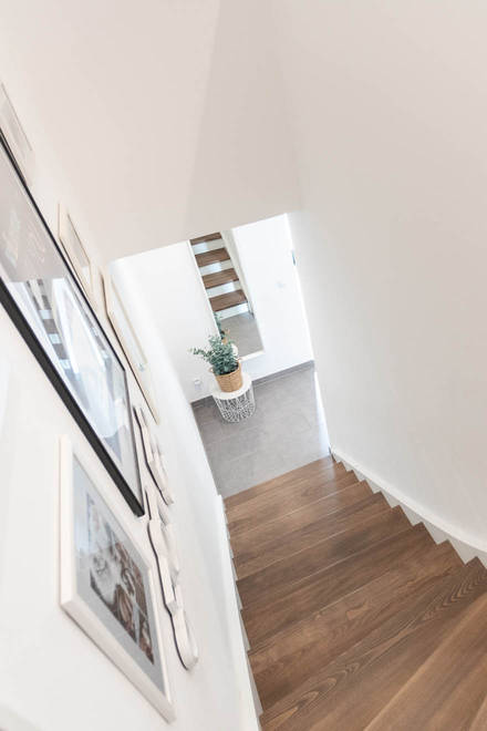 Die schöne und moderne Treppe mit Holzstufen und ohne Geländer führt in die zweite Etage mit Eltern- und Kinderschlafzimmer und dem großzügigen Familienbad. 