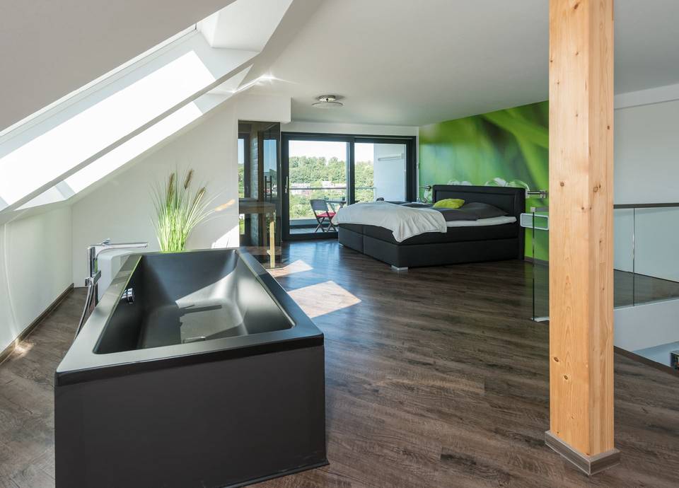 Eine Portion Luxus: Die freistehende Badewanne und der freie Blick ins Grüne sorgen für einen hohen Wohlfühlfaktor in dem individuellen Fertighaus.