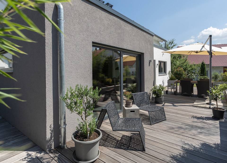 Die großzügige Terrasse des Fertighauses von Büdenbender lädt zum Entspannen in der Sonne ein.