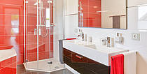 Musterhaus Florenzo, Badezimmer mit roten Fliesen, zwei Waschbecken, Dusche und Badewanne