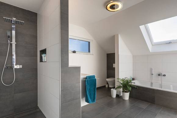 Das moderne Badezimmer mit ebenerdiger Dusche ist nur ein Highlight in dem indivduellen Fertighaus in Straubenhardt.