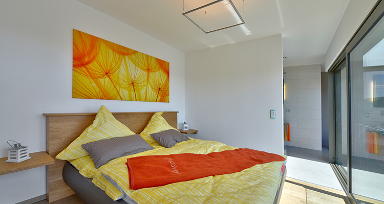 Modernes Schlafzimmer im Musterhaus Valentino von Büdenbender Hausbau