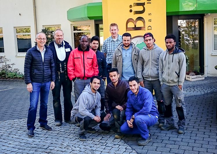 Horst Grübener mit jungen Flüchtlingen zu Besuch bei Büdenbender Hausbau