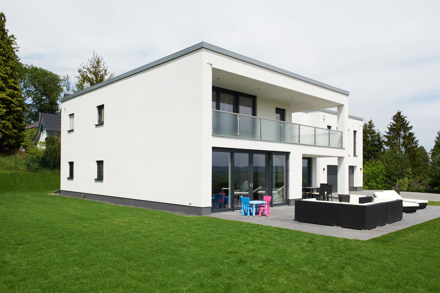 Im individuellen Architektenhaus Calando sorgen große Fensterflächen für lichtdurchflutete und freundliche Räume. Das Obergeschoss wird in einen Eltern- und Kinderbereich geteilt. Im Elternbereich sorgt der überdachte Balkon für Entspannung.